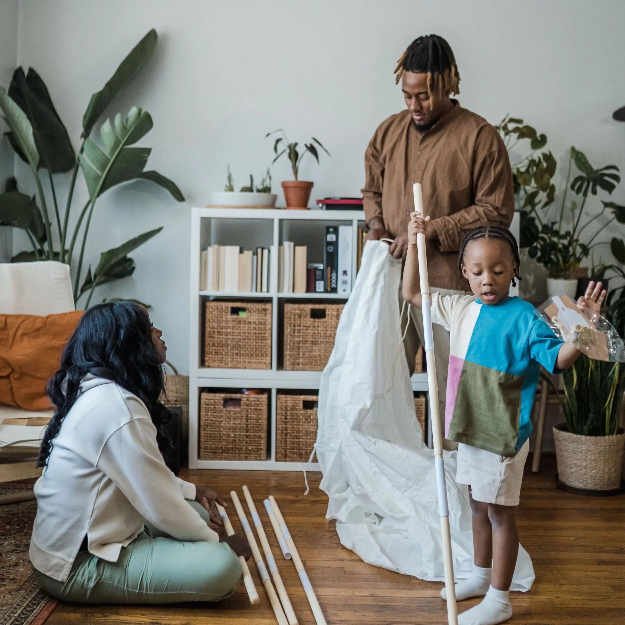 A family assembles furniture in a cozy living room, discussing second mortgage rates as plants and shelves decorate the background.